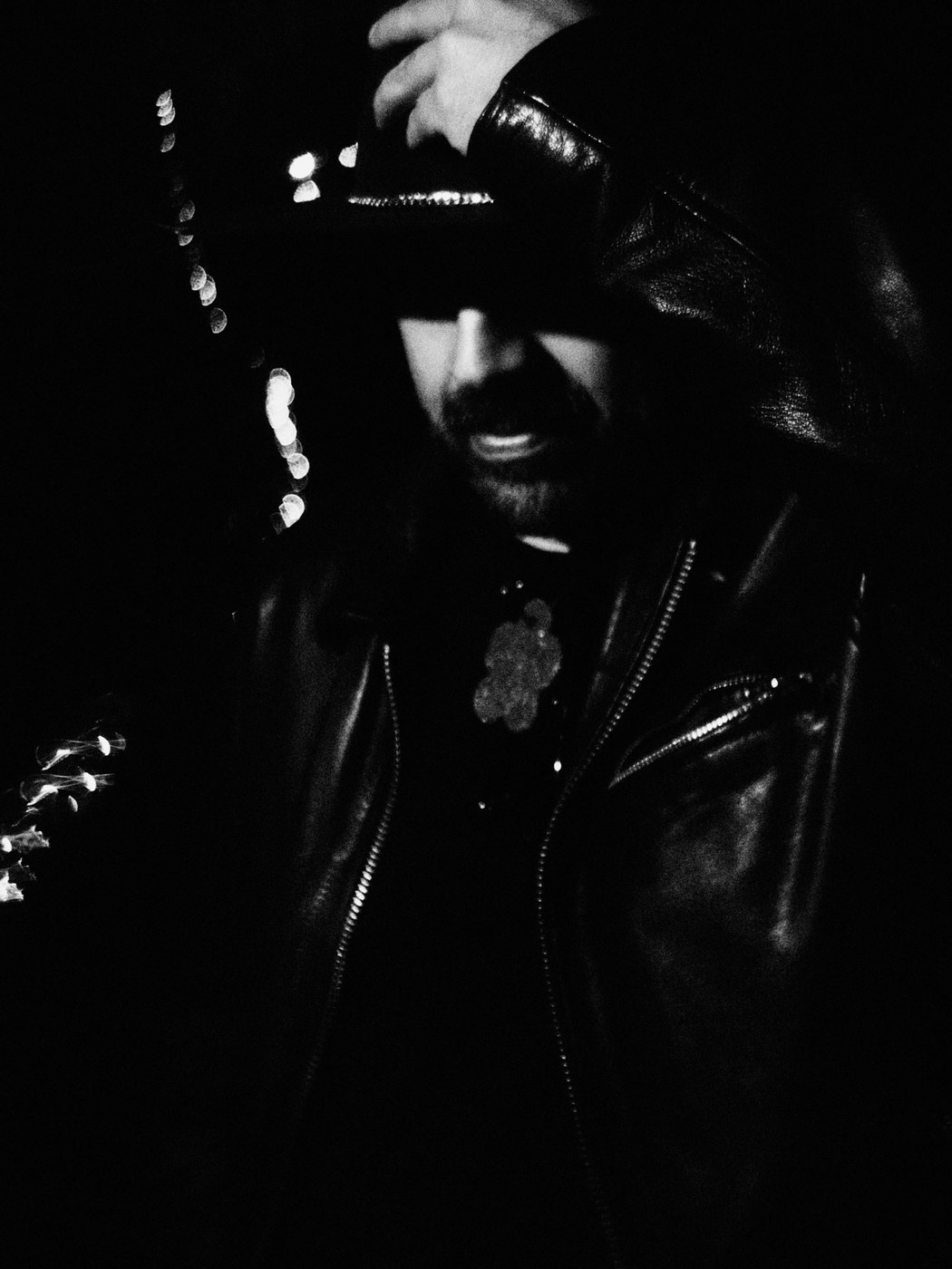 Black-and-white portrait of Frankie Owls in a leather jacket and hat